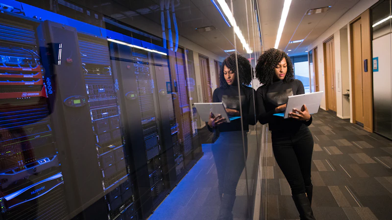 IT technician with a laptop testing backups in a data center