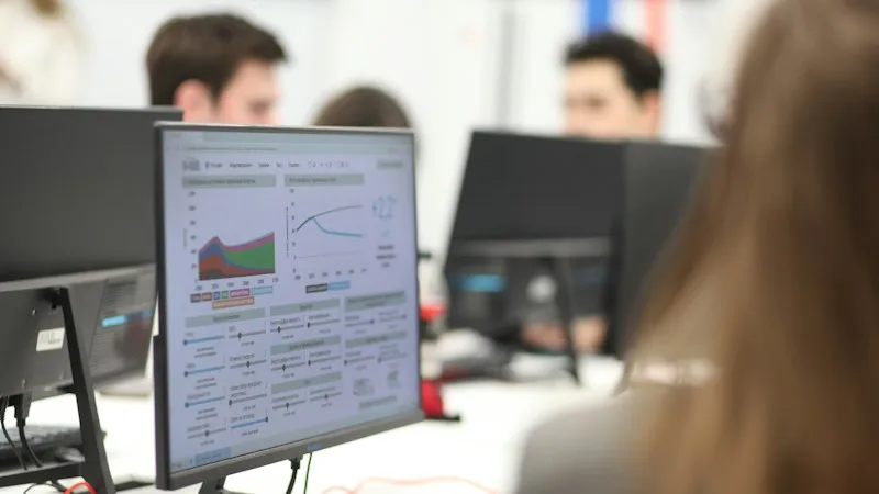 IT team working at computers with monitoring dashboards on screen