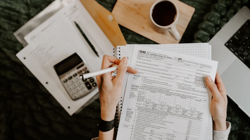 Person reviewing compliance paperwork with a calculator