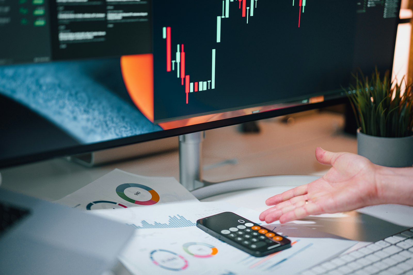 Accountant using a calculator next to financial charts