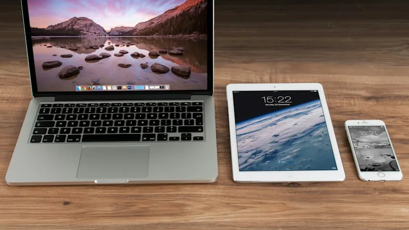 Laptop, tablet, and smartphone on a desk representing managed devices