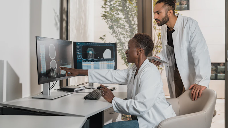 Clinicians reviewing medical scans at a computer workstation