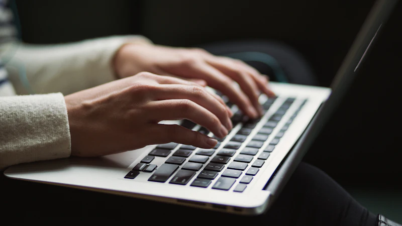 Hands typing on a laptop while working in email and cloud apps
