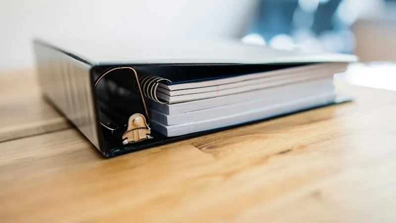 Binder of written security policies and procedures on a desk