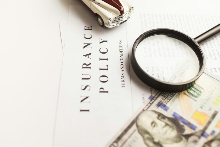 Magnifying glass resting on an insurance policy document