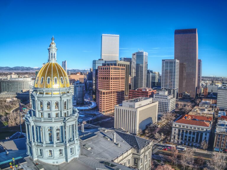 Gold dome of the Colorado State Capitol with downtown Denver high rises
