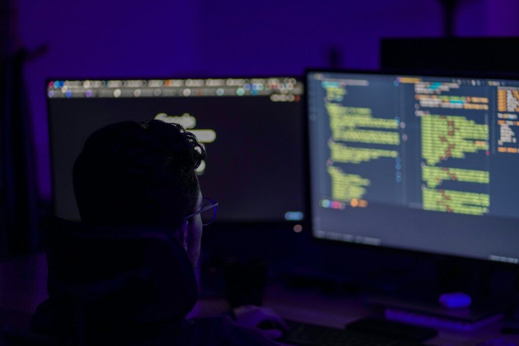 Security analyst watching monitors in a dark operations room