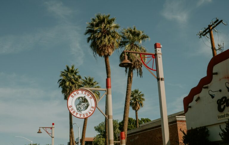 Old Town Scottsdale sign and palm trees against a blue sky