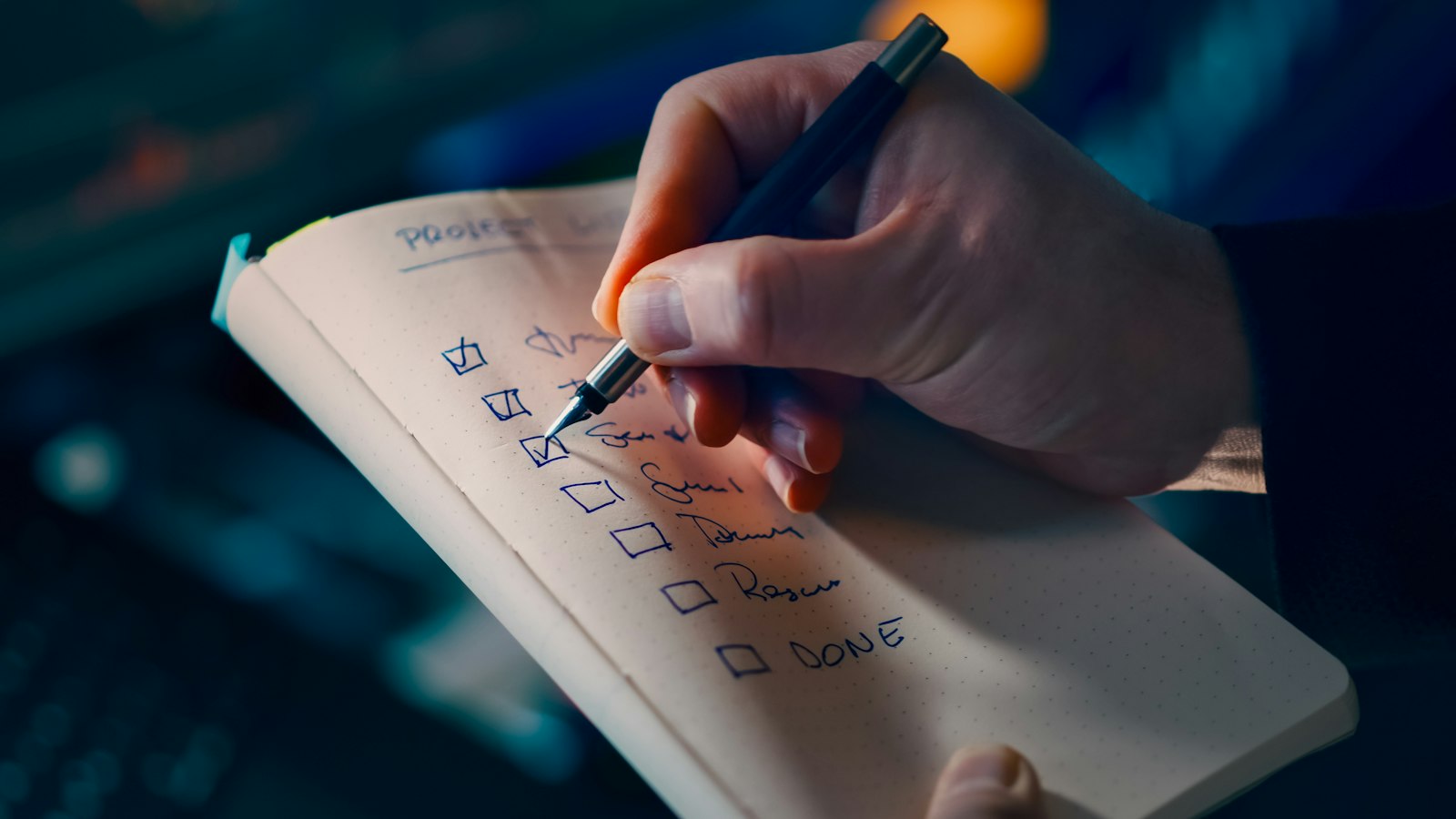 Hand checking off items on a handwritten year-end checklist